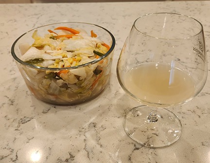 Homemade white kimchi alongside bacteria-rich “kimchi juice” that could be used for a kettle sour.
