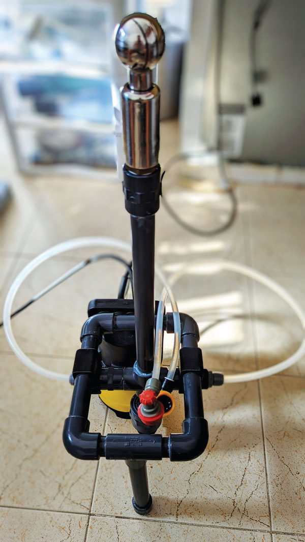 homemade keg washer with a PVC piping and base, and a spray ball