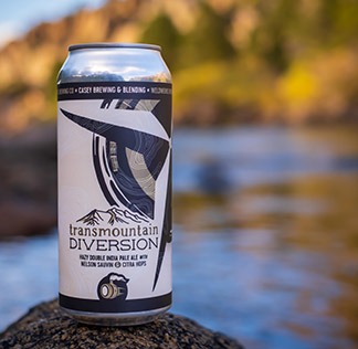 Can of Transmountain Diversion beer with lake in the background.